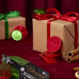 A stack of red Divine fairtrade dark chocolate coins against a Christmas present. Coins available at Babipur.