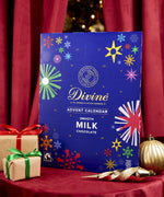 Divine fairtrade milk chocolate advent calendar available at Babipur. Showing the front of the calendar. Calendar is standing in a festive display.