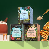 All three Divine fairtrade hot chocolate  boxes displayed on a green platform, shows a golden spoon and a mug of hot chocolate
