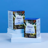 2 boxes of Divine fairtrade luxury hot chocolate boxes standing on a light blue platform