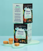 Divine fairtrade salted caramel flavour hot chocolate box standing on a mint green platform with another box on top