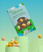 Divine Fairtrade milk chocolate mini eggs with hazelnut praline displayed in a decorated blue and green box balancing on a green platform 