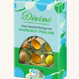 Side of Divine Fairtrade milk chocolate mini eggs with hazelnut praline displayed in a decorated blue and green box