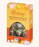 Side of Divine Fairtrade milk chocolate mini eggs with smooth caramel displayed in a decorated yellow and orange box 