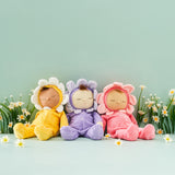 A group of Dozy Dinkum Dolls - Fuchsia Twinkle, Buttercup Pip, Lavender Pickle by Olli Ella, a small baby doll dressed in a pink, purple and yellow velour outfits and flower hood, sold at Babipur.