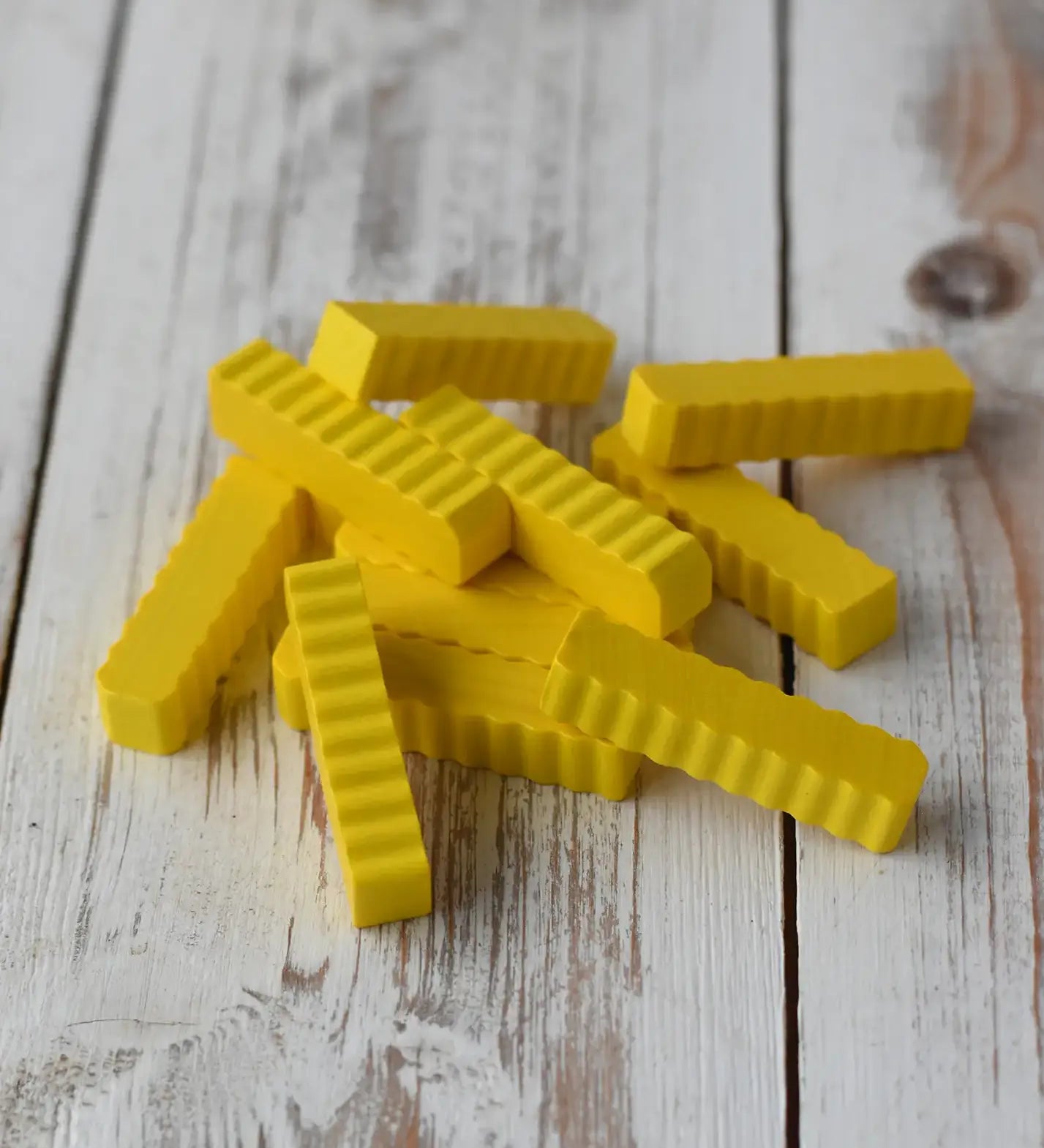Erzi wooden play food crinkle cut chips placed on a wooden surface. 