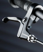 Close up on the brake on the Early rider auto belter bike showing a rubber handle bar and short levers