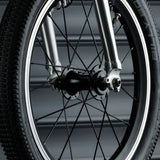 Close up of the wheel on the Early Rider bike showing rubber tyres, metal spokes and air valve