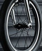 Close up of the wheel on the Early Rider bike showing rubber tyres, metal spokes and air valve