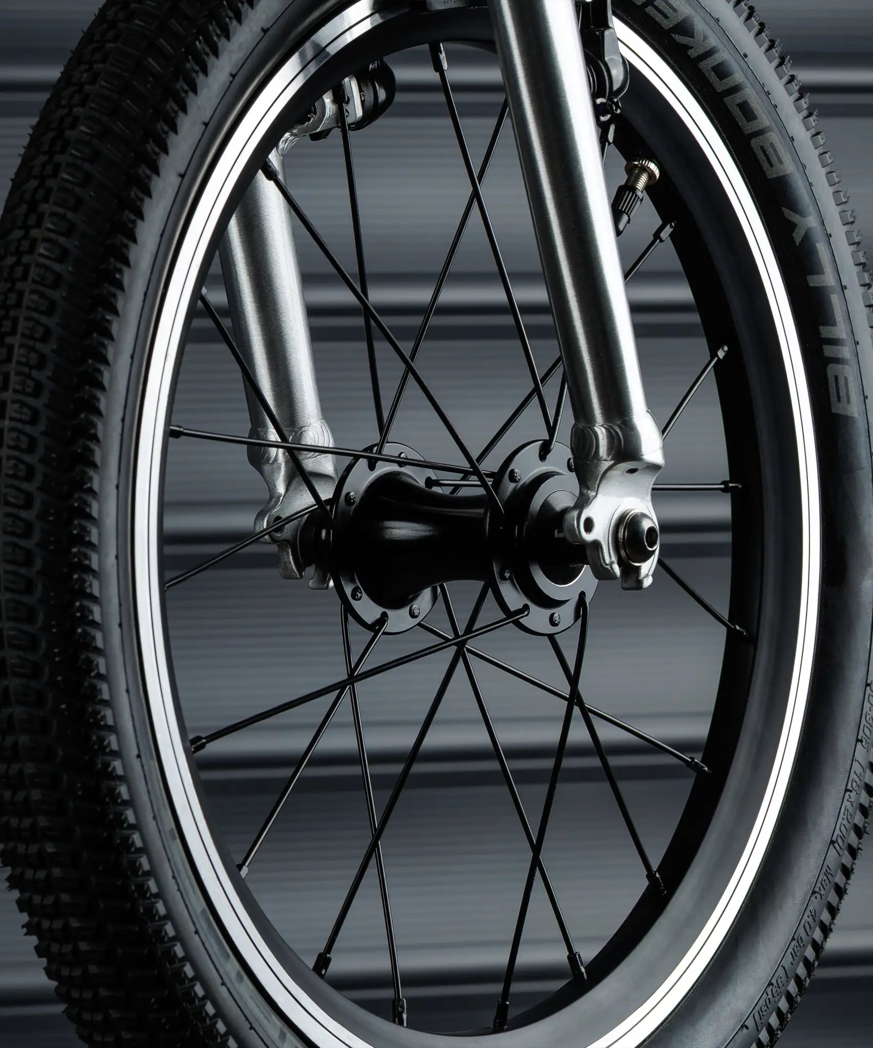 Close up of the wheel on the Early Rider bike showing rubber tyres, metal spokes and air valve