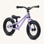 Early Rider Charger Balance Bike - Violet Haze, at a side on view. The balance bike has a violet low slung frame, chunky black wheels, a clack seat and black handle bars and is on a cream background