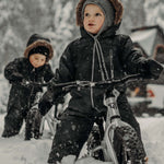 Two children playing in the snow on their Early Rider Big Foot Balance Bikes. The image shows how sturdy the Early Rider bikes are, and can be used in deep snow