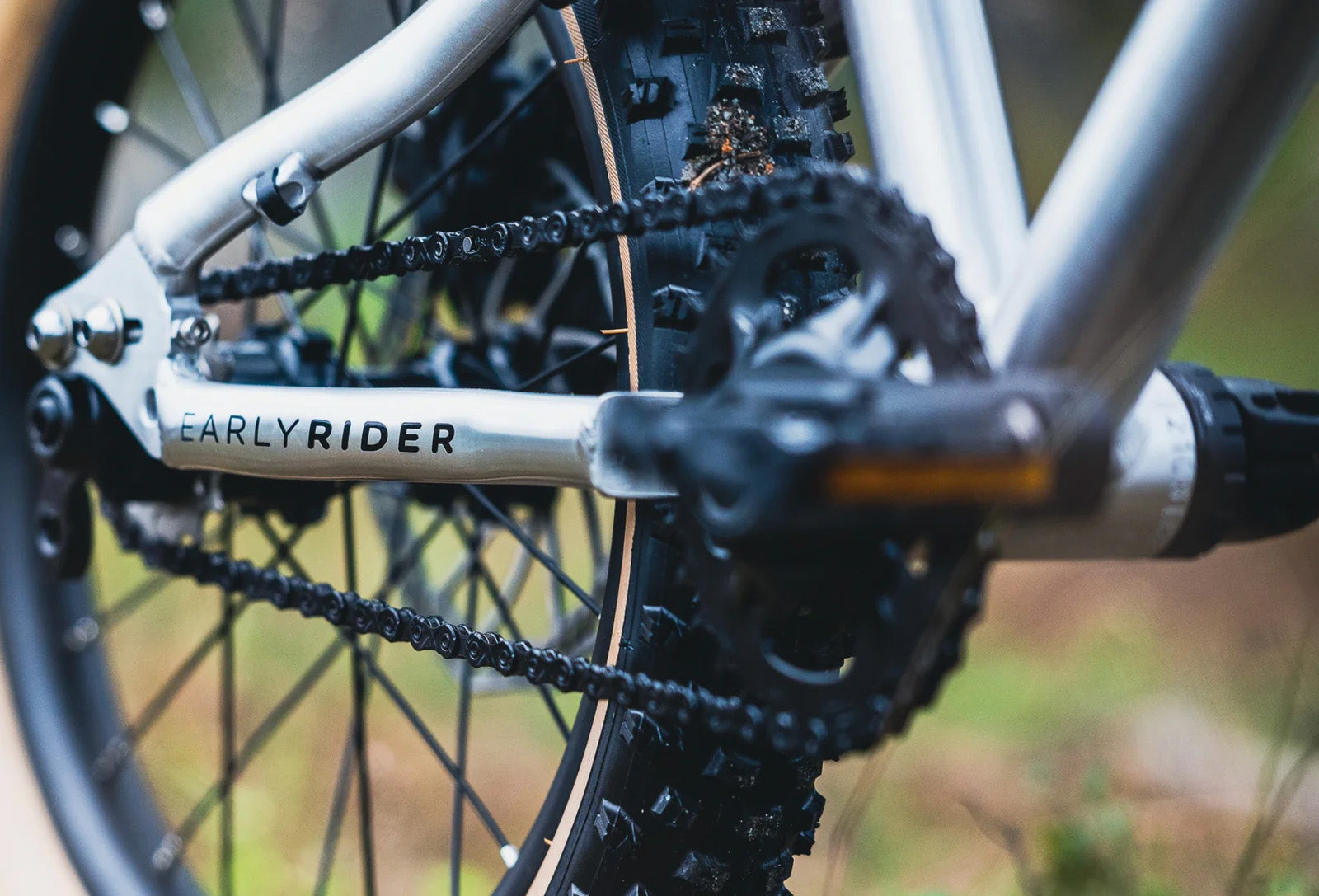 Close-up of a bicycle chain and gear system with 'EARLYRIDER' branding.