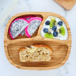 Bamboo baby section plate with banana loaf, dragonfruit slices and yogurt with fresh fruit and berries. 
