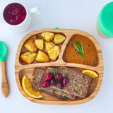 Bamboo baby section plate with roast potatoes, gravy and rye bread slices.