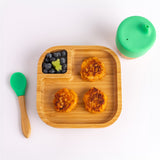 A top view of the Eco Rascals Natural Bamboo Square Plate, between an Eco Rascals Sippy Cup and Eco Rascals Spoon