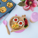 Eco Rascals Snail Plate, Feeder Cup, Bowl & Spoon Gift Set in Pink, with various food items surrounding