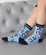 A close up of a child wearing the Eco kiddies organic cotton friendly penguins socks showing the cute playful penguin design detail and branding on the sole 