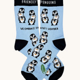 Eco kiddies friendly penguins organic cotton kids socks. A light blue sock with black trim and features cute playful penguins with a slogan saying 'we embrace earth's weather' 