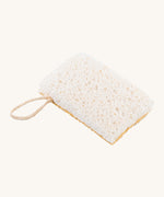 A image of the sponge side of the Ecoliving loofah kitchen sponge scrubber available at Babipur. A double sided scrubber, features a loofah side and a sponge side with a loop of thread for hanging. 
