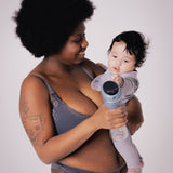 A parent holding their child, with the child reaching towards the Lola&Lykke Smart Electric Breast Pump