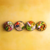 A row of Elephant Box lunch bowls available at Babipur. Bowls are without their lids and showing each bowl full of different foods. 
