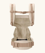 Back of Ergobaby omni 360 baby carrier in natural beige showing quick release buckle on shoulder straps 