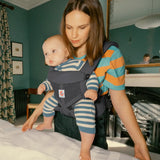 Mother carrying baby in the Ergobaby charcoal grey omni 360 air mesh carrier in the bedroom 