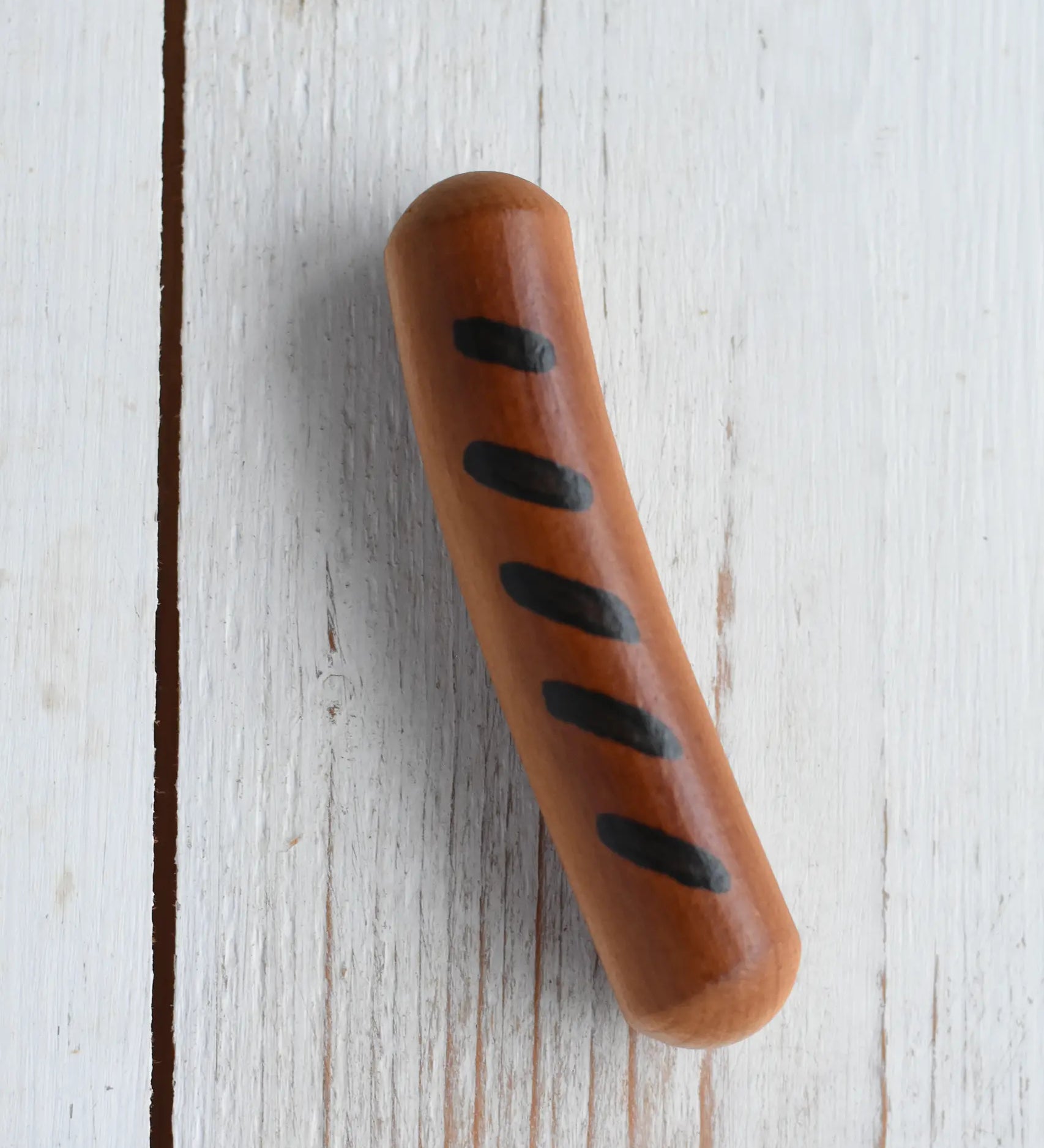 Erzi Frying Sausage Wooden Play Food placed on a wooden surface. Cooked toy sausage with grill marks.