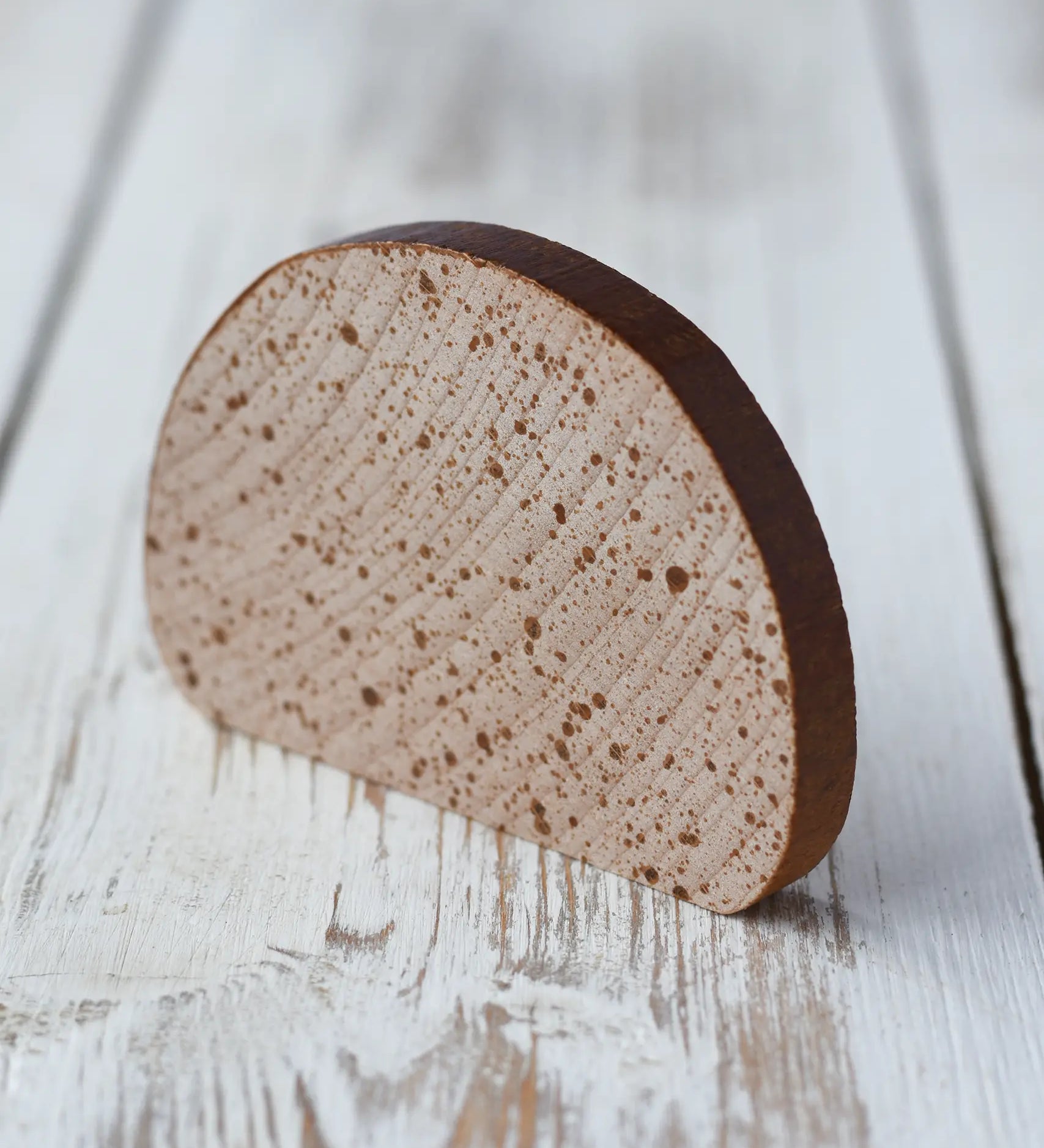Erzi Slice of Bread Wooden Play Food placed on a wooden surface. Speckled slice of bread with a dark edge crust.