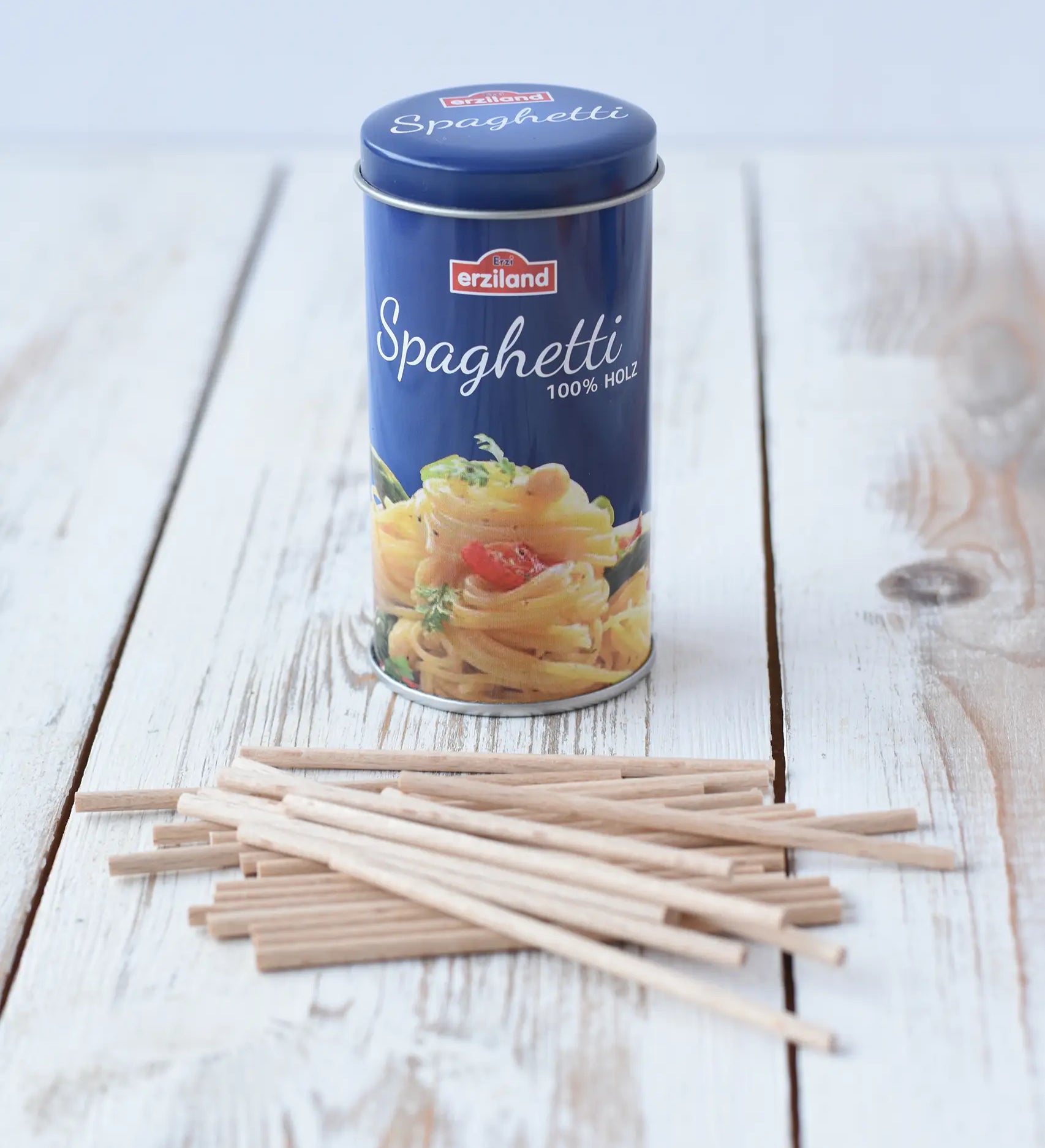 Erzi Spaghetti in a tin wooden play food, the wooden spaghetti strands have been placed in front of the blue tin.