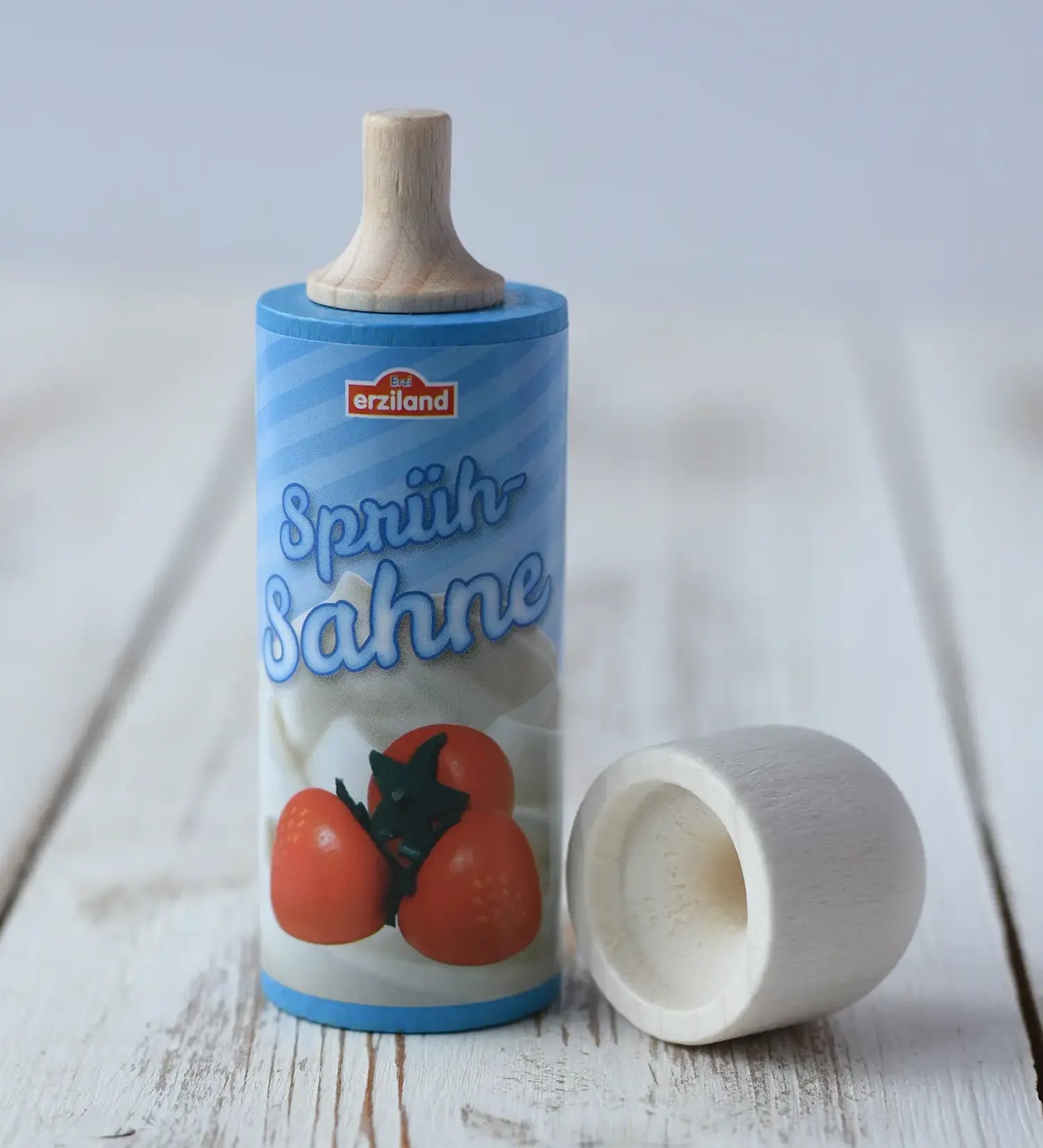 Erzi Toys Whipped squirty Cream wooden play food with the lid taken off placed on a wooden surface.