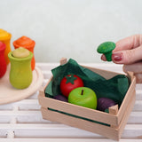 A hand holding a small wooden broccoli toy by Erzi, perfect for a play kitchen, sold at Babipur.