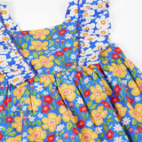 Frugi 100% organic cotton Audrey dress in blue laid flat showing the different repeating floral design.and shoulder straps