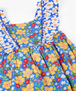 Frugi 100% organic cotton Audrey dress in blue laid flat showing the different repeating floral design.and shoulder straps