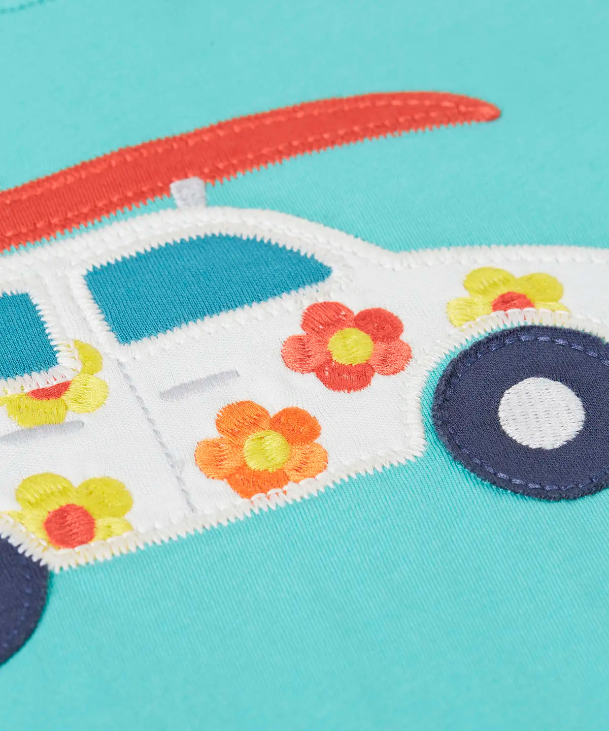 Close up of Frugi's 100% organic cotton short sleeve t-shirt in light blue showing white with flowers car patch detail