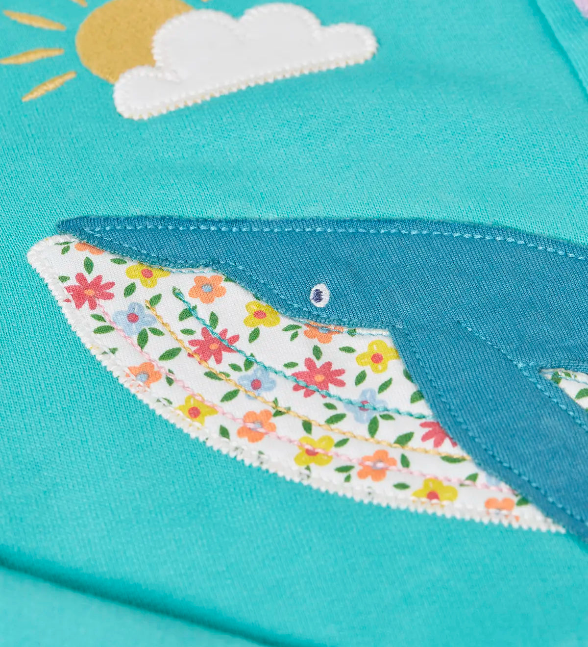 Close up of the whale patch on the Frugi 100% organic cotton carbis hoody in blue 