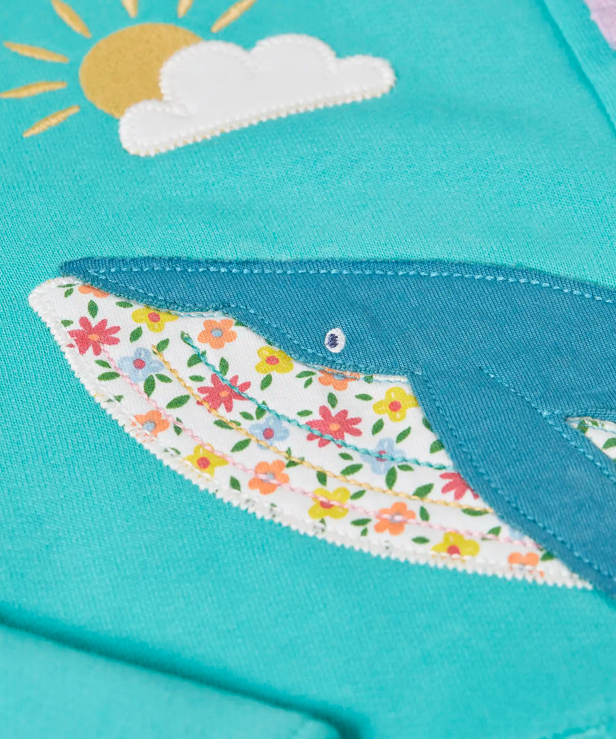 Close up of the whale patch on the Frugi 100% organic cotton carbis hoody in blue 