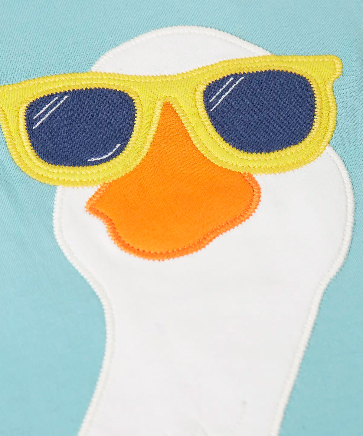 Close up of the playful white goose patch wearing sunglasses on the Frugi 100% organic cotton short sleeve t-shirt in light blue 