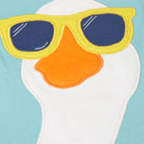 Close up of the playful white goose patch wearing sunglasses on the Frugi 100% organic cotton short sleeve t-shirt in light blue 