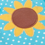 Close up of Frugi 100% organic cotton Dora playsuit in blue with white dots showing sunflower patch detail