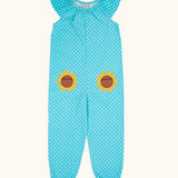Frugi 100% organic cotton Dora playsuit in blue with white dots and sunflower patches on the front. Showing elasticated neck line