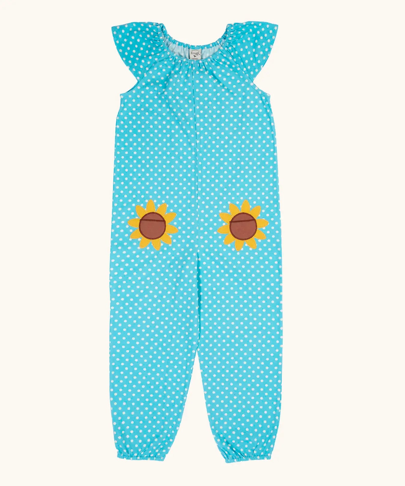 Frugi 100% organic cotton Dora playsuit in blue with white dots and sunflower patches on the front. Showing elasticated neck line