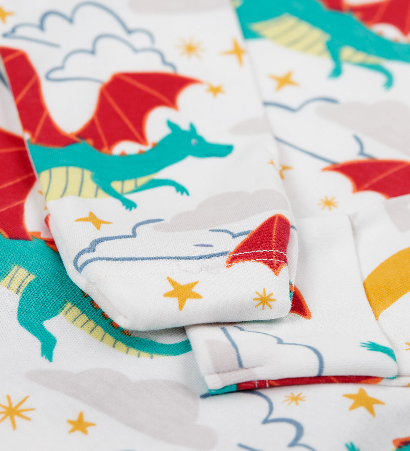 A close up of the cuff detail on the Frugi easy dressing printed babygrow in dragon skies available at Babipur. 
