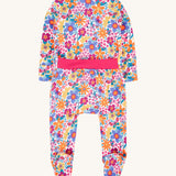 The back of the Frugi easy dressing printed babygrow in white/retro floral design available at Babipur. A GOTS organic cotton all in one with a bright retro floral design and pink trim around the waist