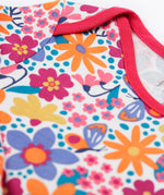 A close up of the pink trim detail on the neck and shoulder on the Frugi easy dressing printed babygrow in white/retro floral design available at Babipur.