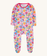 Frugi easy dressing printed babygrow in white/retro floral design available at Babipur. A GOTS organic cotton all in one with a bright retro floral design and pink trim around the neck and shoulder.