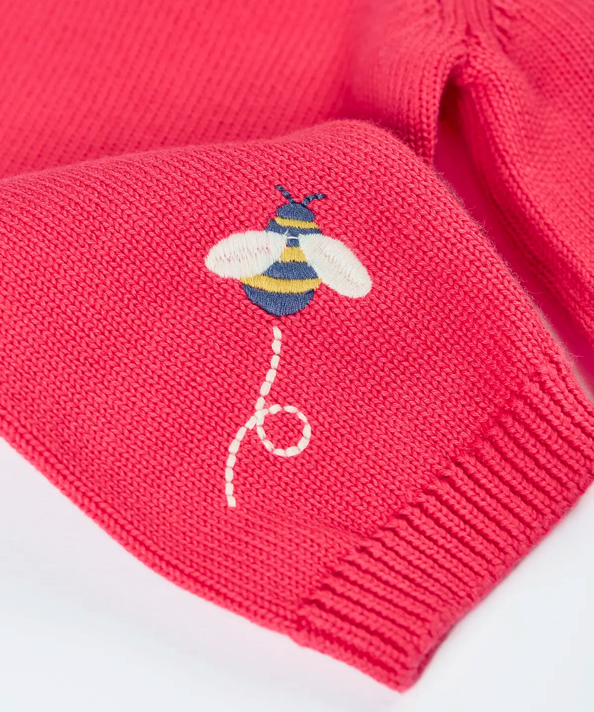 Close up of bee embroidery on the sleeve of the Frugi 100% organic cotton Ella cardigan in pink 