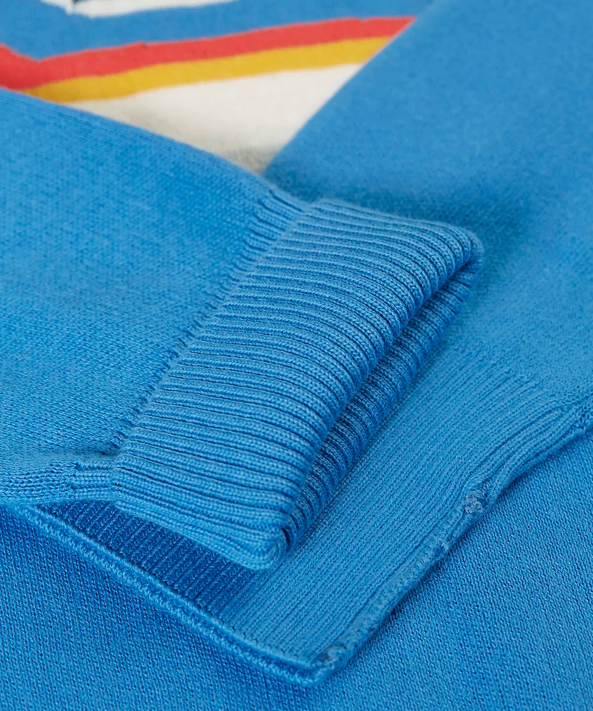 Close up of the Frugi 100% organic cotton Elwood knitted jumper in blue showing a turned up cuff