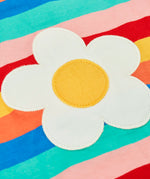 Close up of the white daisy patch on the Frugi 100% organic cotton short sleeve Fiona t-shirt in rainbow stripes 